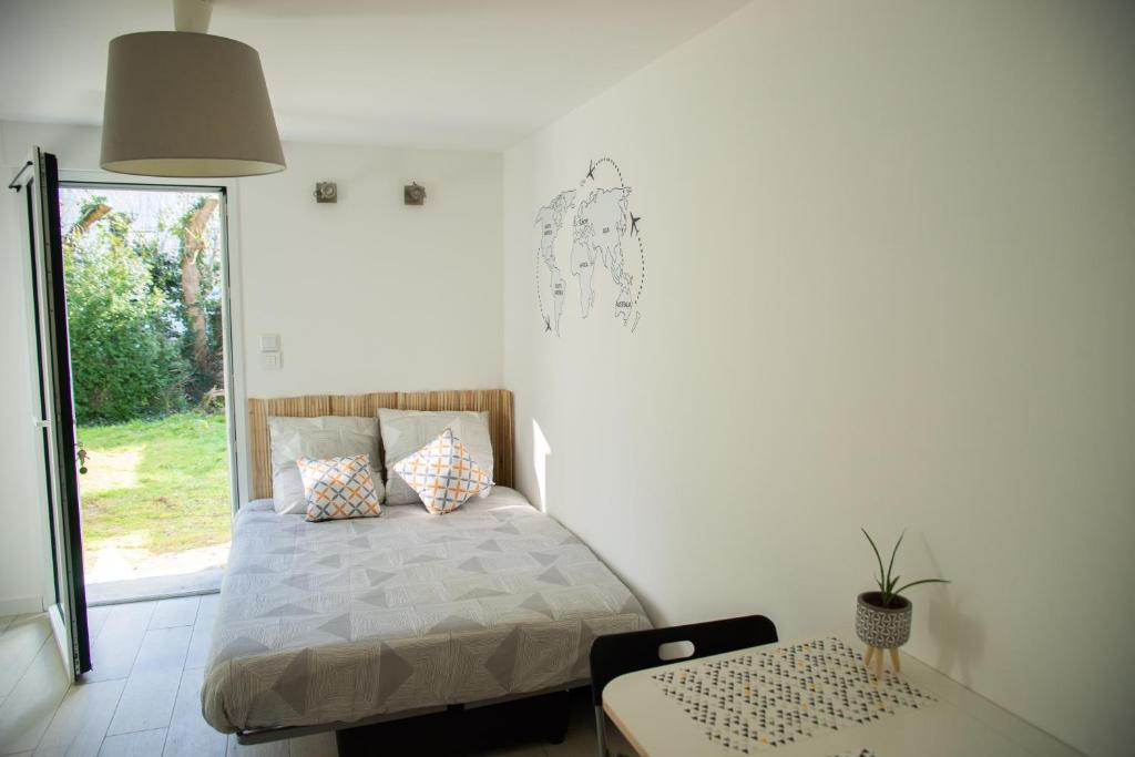 サン・セバスティアン・シュル・ロワールにあるAu clos du bonheurのベッドルーム1室(ベッド1台、テーブル、窓付)