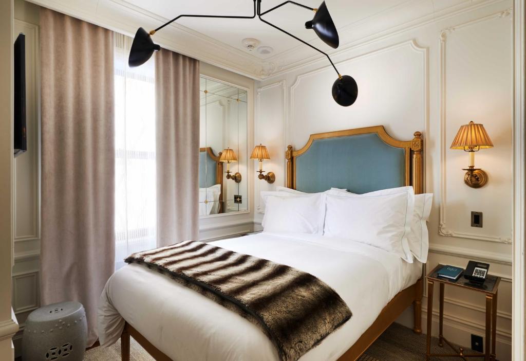 a bedroom with a large bed with white pillows at The Marlton Hotel in New York