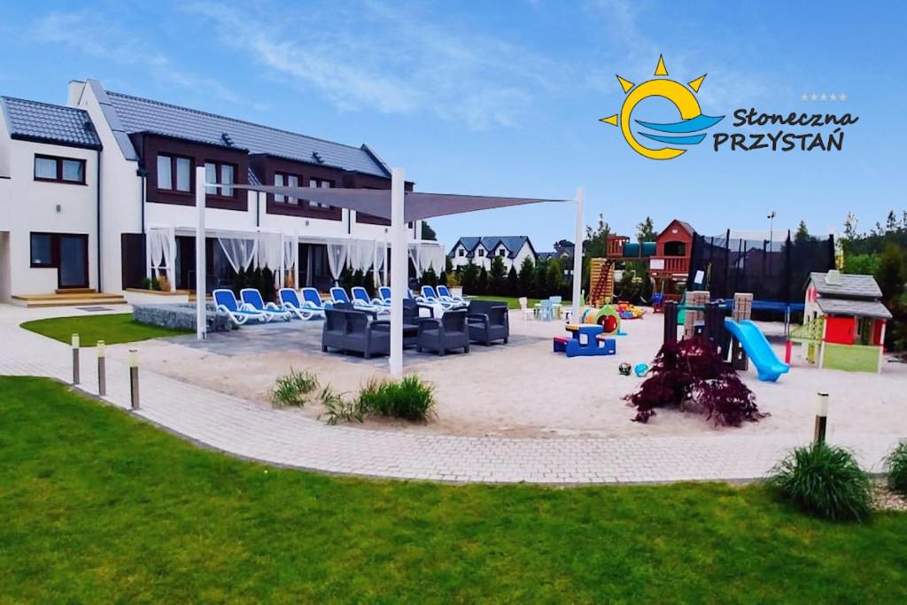 a playground in front of a large building with a playground at Słoneczna PRZYSTAŃ in Dębki