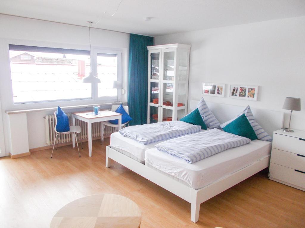 um quarto com uma cama, uma mesa e uma janela em Nebelhorn Appartement 207 em Oberstdorf