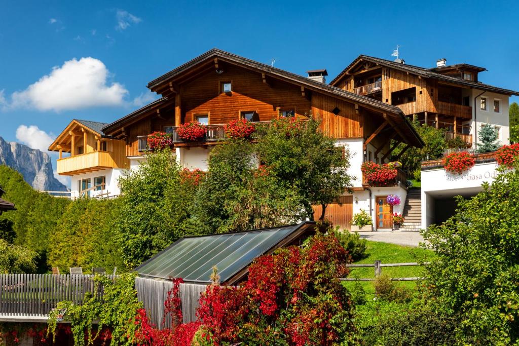 una casa en las montañas con flores en el patio en Ciasa Odlana, en San Cassiano