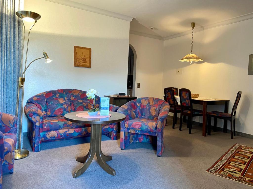 - un salon avec un canapé, des chaises et une table dans l'établissement Haus Dwarslöper, Ferienwohnung 2, à Cuxhaven