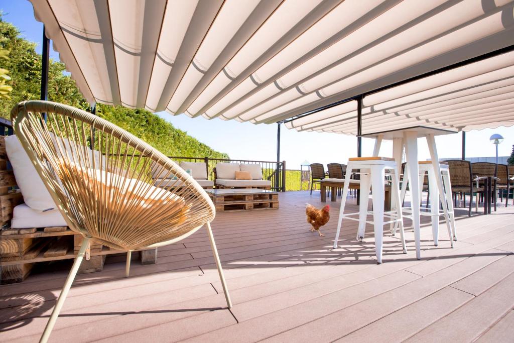 a deck with chairs and a table and a couch at Hotel Salamanca Montalvo in Salamanca