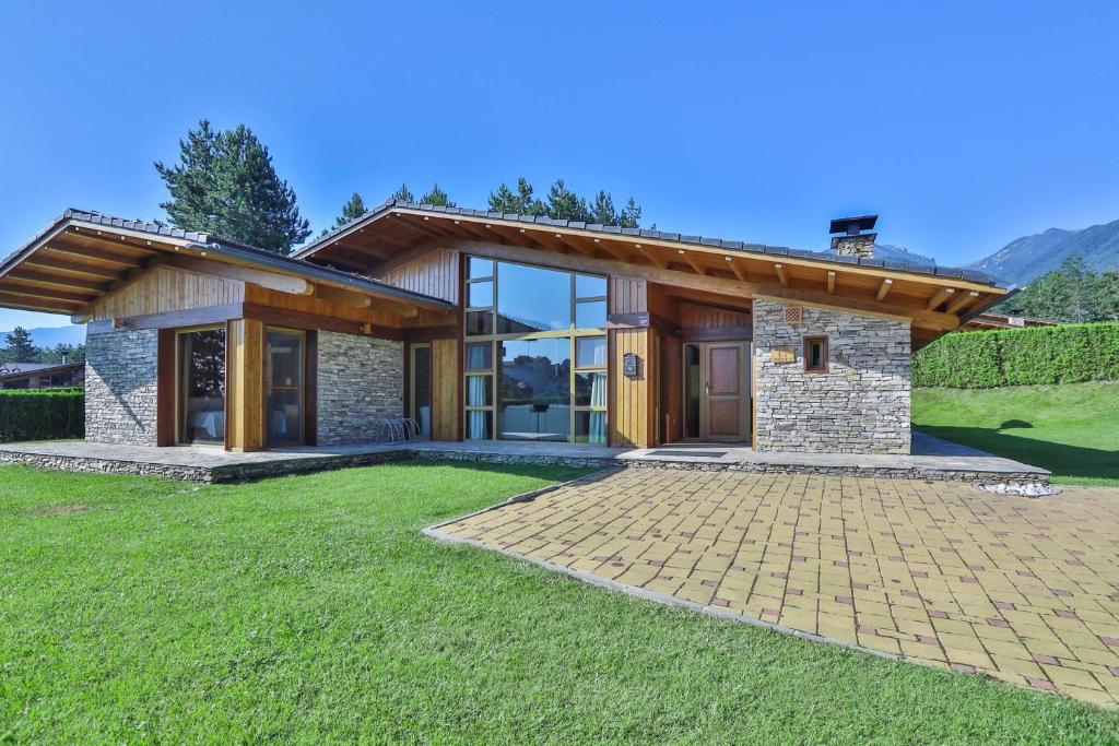 a house with a stone and wood facade at Luxury Chalets Pirin Golf & Country Club in Bansko
