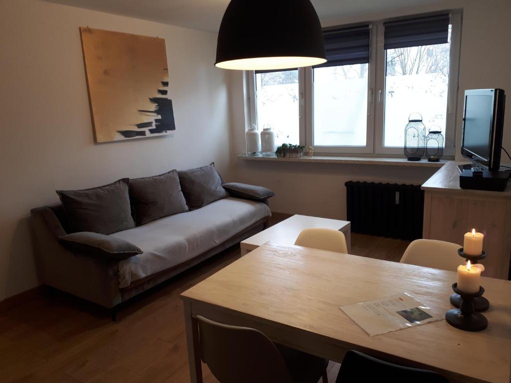 een woonkamer met een bank en een tafel bij Studio park Katowice/Chorzów in Chorzów