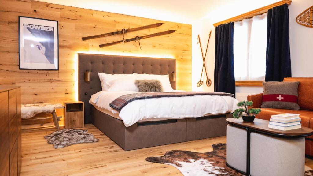 1 dormitorio con 1 cama grande y 1 sofá en Wunderstay Alpine 3 Chic Studio Central Location en Klosters Serneus