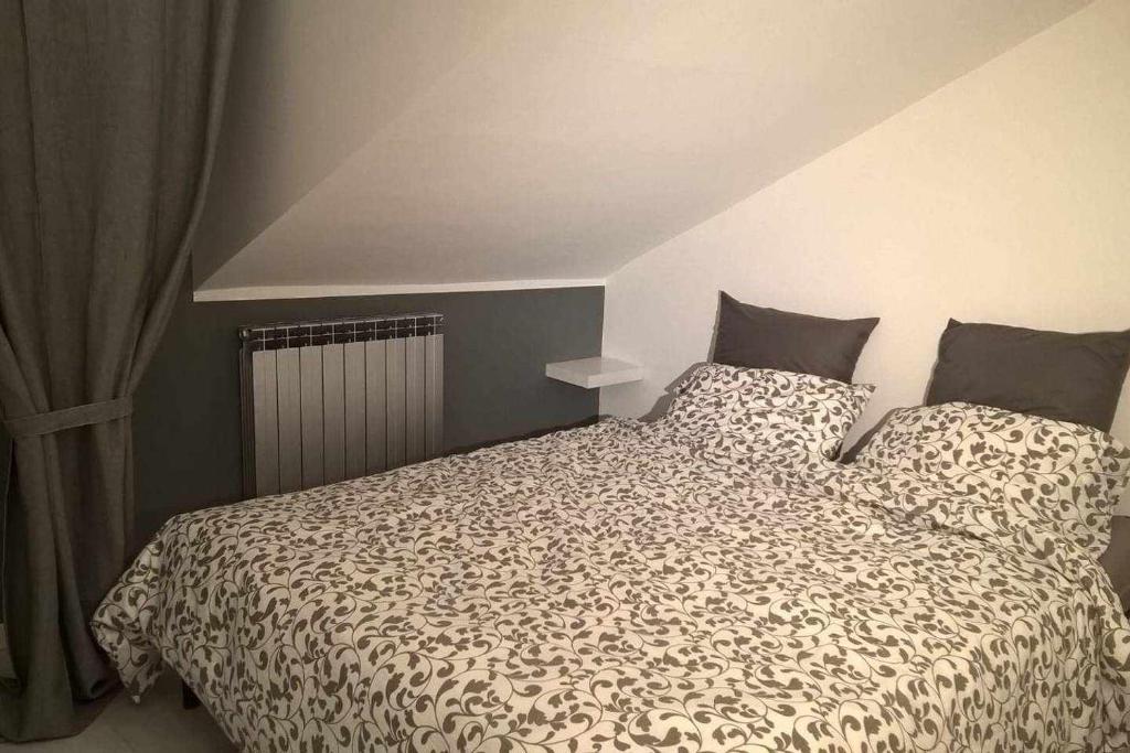 Schlafzimmer mit einem Bett mit einer schwarzen und weißen Bettdecke in der Unterkunft Joie de Vivre Torino Statuto in Turin