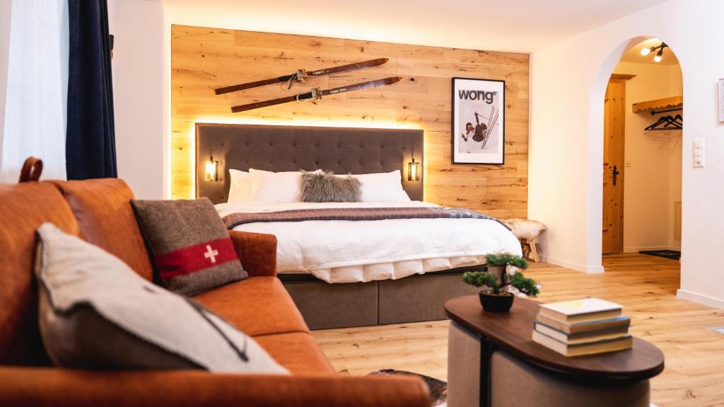 1 dormitorio con 1 cama y 1 sofá en Wunderstay Alpine 16 Chic Studio Central Location en Klosters Serneus