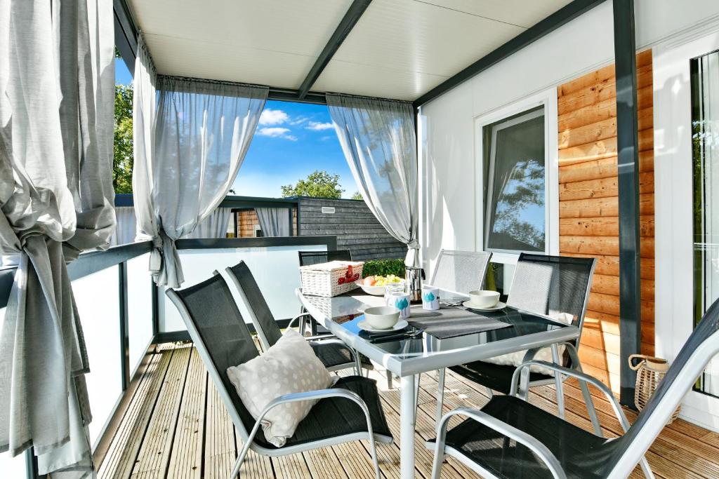 a patio with a table and chairs on a deck at Polidor Camping Resort in Poreč