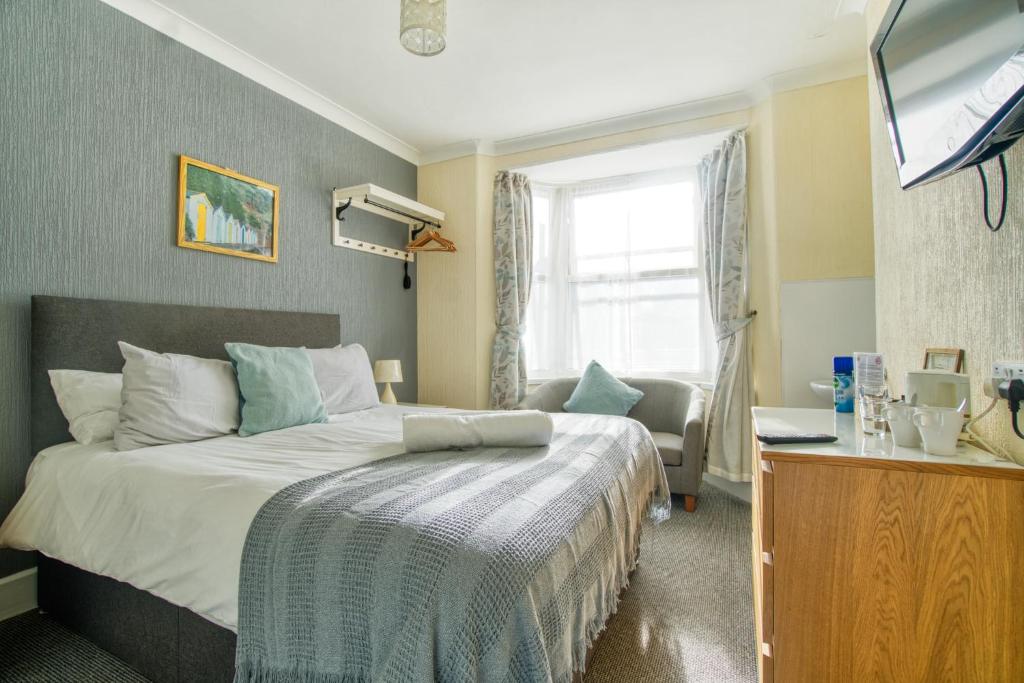 a hotel room with a bed and a television at St Weonards in Paignton