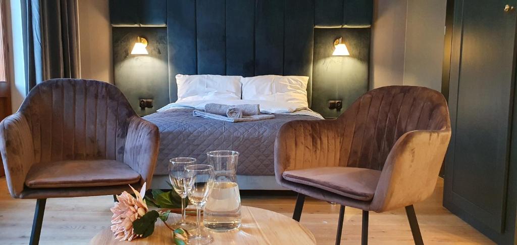 オルシュティンにあるDK Premium Warmińska Secesjaのベッドルーム1室(ベッド1台、椅子2脚、テーブル付)
