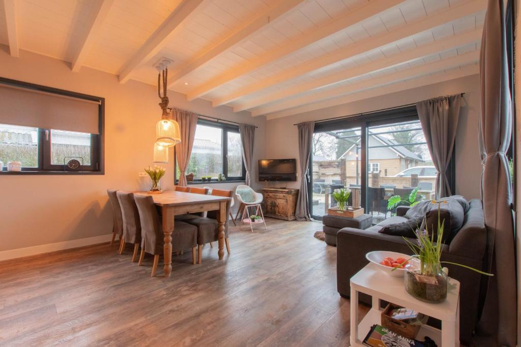 a living room with a table and a couch at Stijlvol ingerichte bungalow in Baarland in Baarland