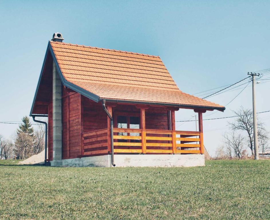 a small building with an orange roof on a field at Brvnara Zečević in Zlatibor