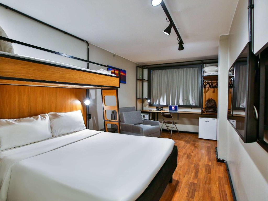 リオデジャネイロにあるibis Copacabana Posto 2のベッドとデスクが備わるホテルルームです。