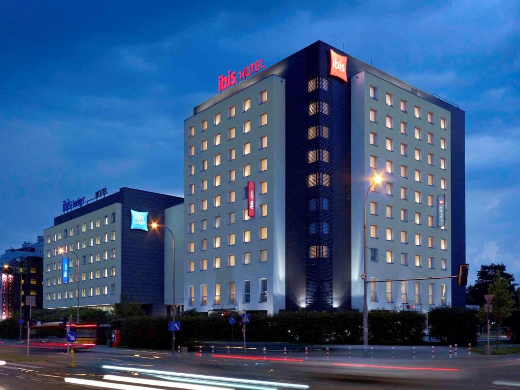 ワルシャワにあるibis Warszawa West Stationの夜間の看板が貼られたホテルの建物