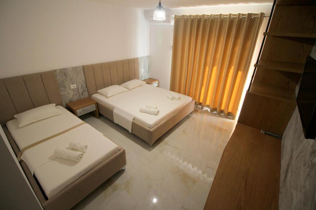 een slaapkamer met 2 bedden en een raam bij Hotel Four Islands in Ksamil