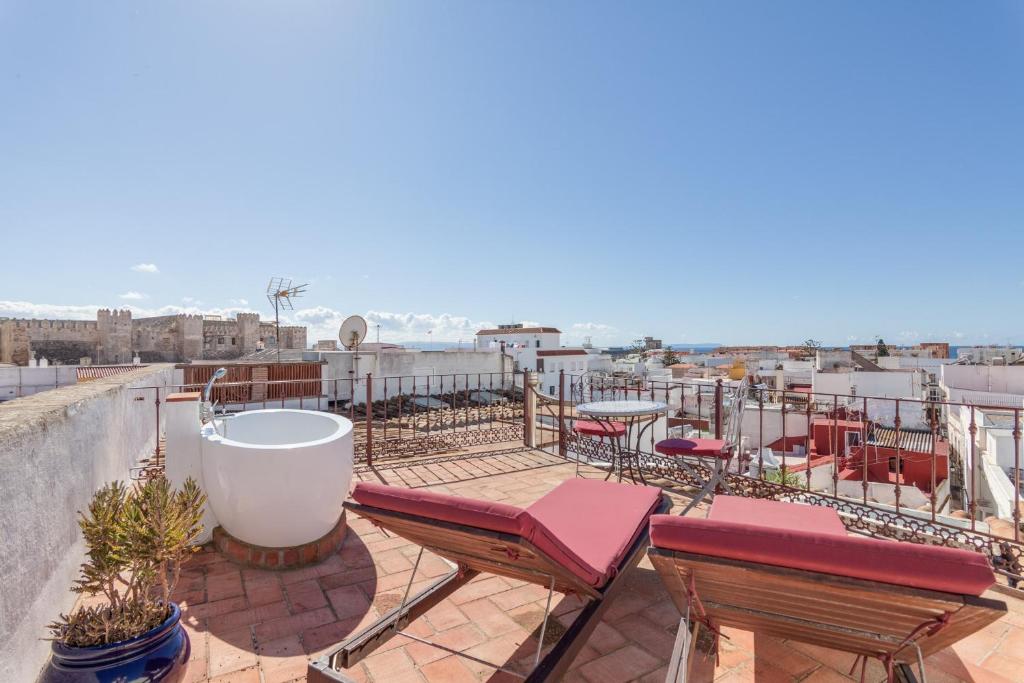un patio con sillas y mesas en la azotea en Ático Al Andalus, en Tarifa