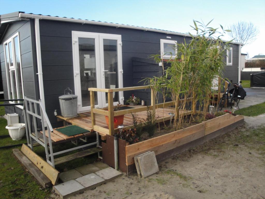 una casa pequeña con terraza y plantas en NV 1219 - Beach Resort Nieuwvliet Bad, en Nieuwvliet