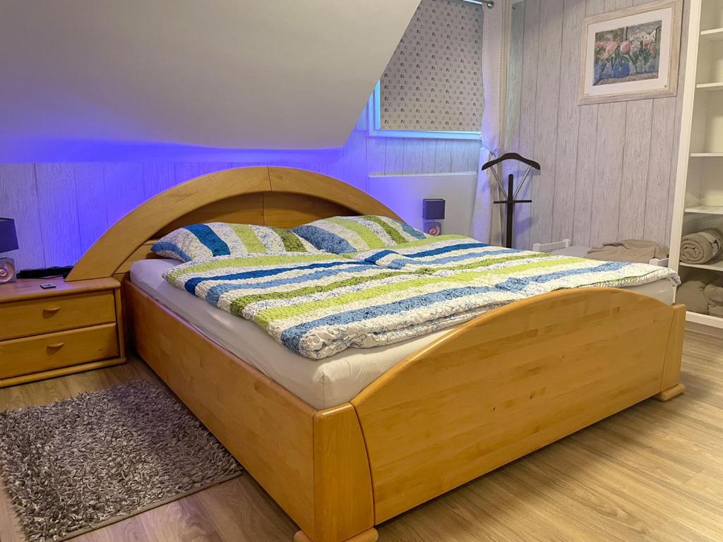 a bed with a wooden frame in a room at Ferienwohnung Köln-Poll in Cologne