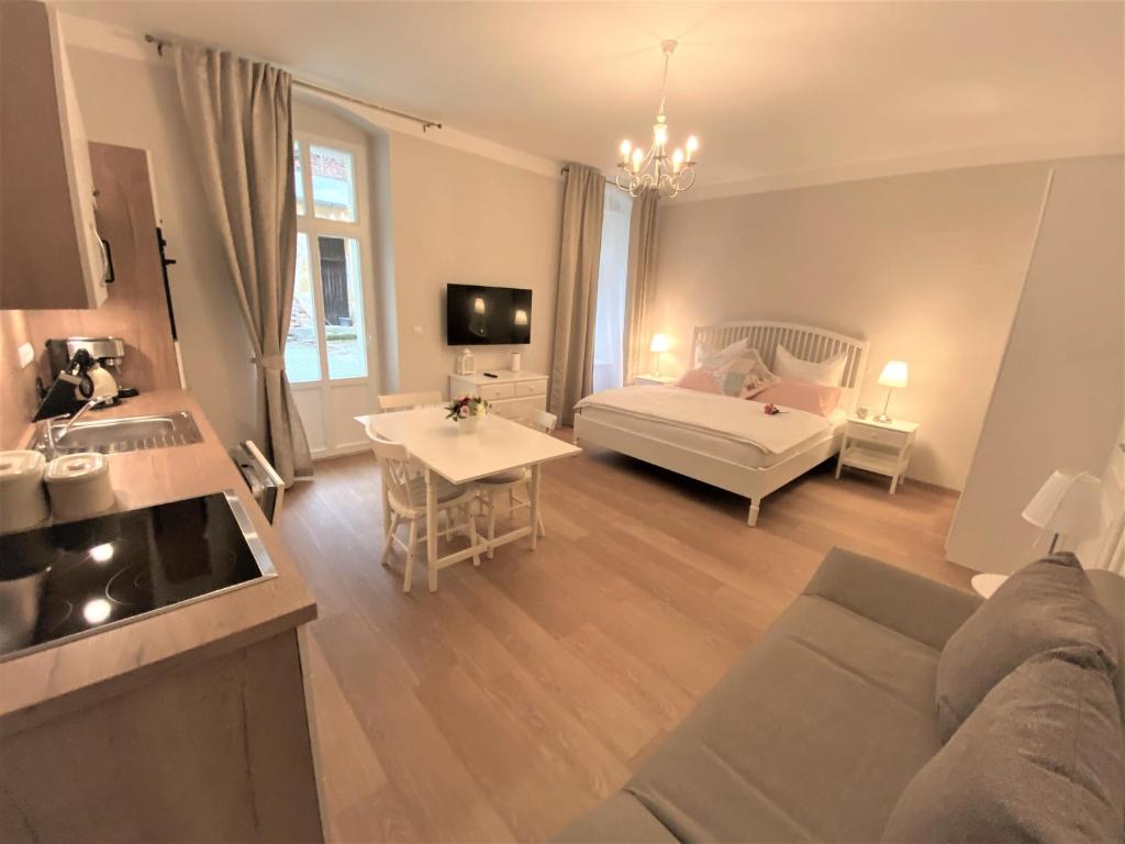 salon z kanapą i łóżkiem w obiekcie Apartments Magnolia w Mariańskich Łaźniach