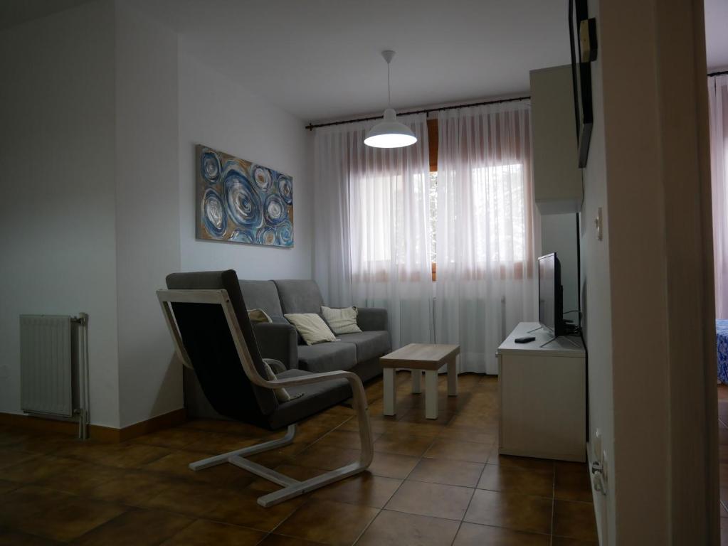 ein Wohnzimmer mit einem Sofa und einem Stuhl in der Unterkunft Principat-Vacances Pirinenca in Incles