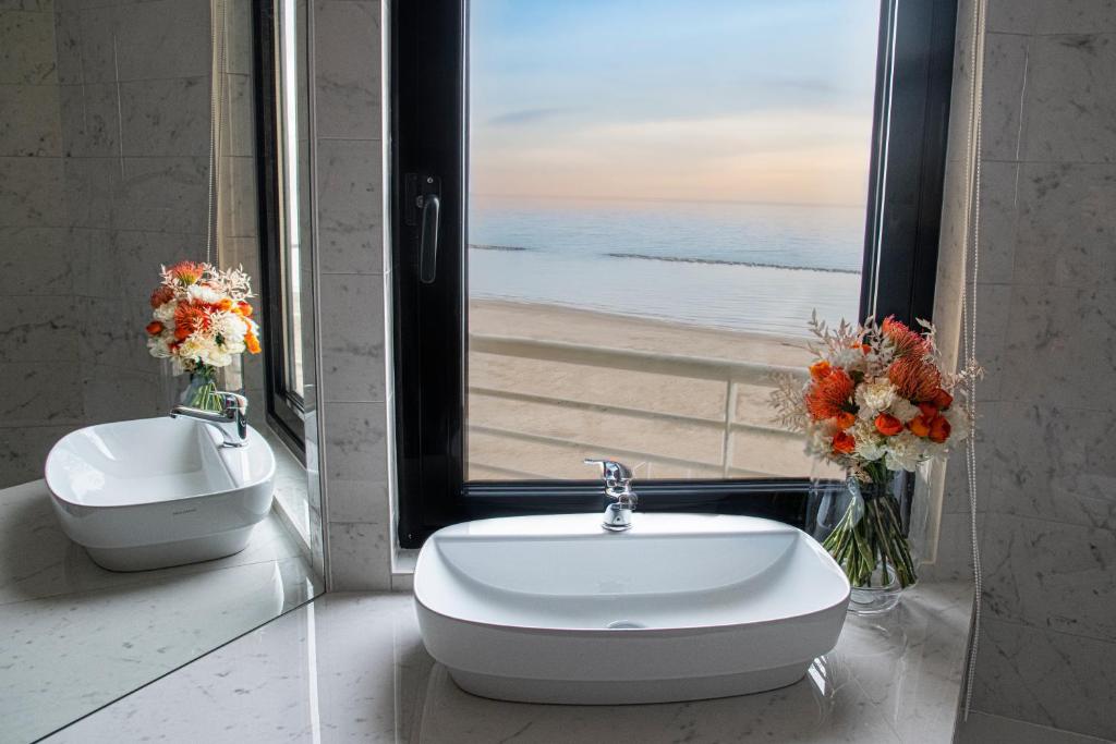 a bathroom with a sink and a view of the beach at AmbientHotels Panoramic in Rimini