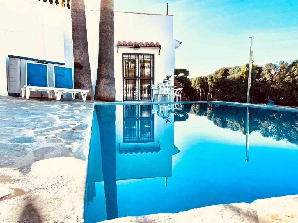 een villa met een zwembad en palmbomen bij Super Exclusive Bungalow in Benalmádena