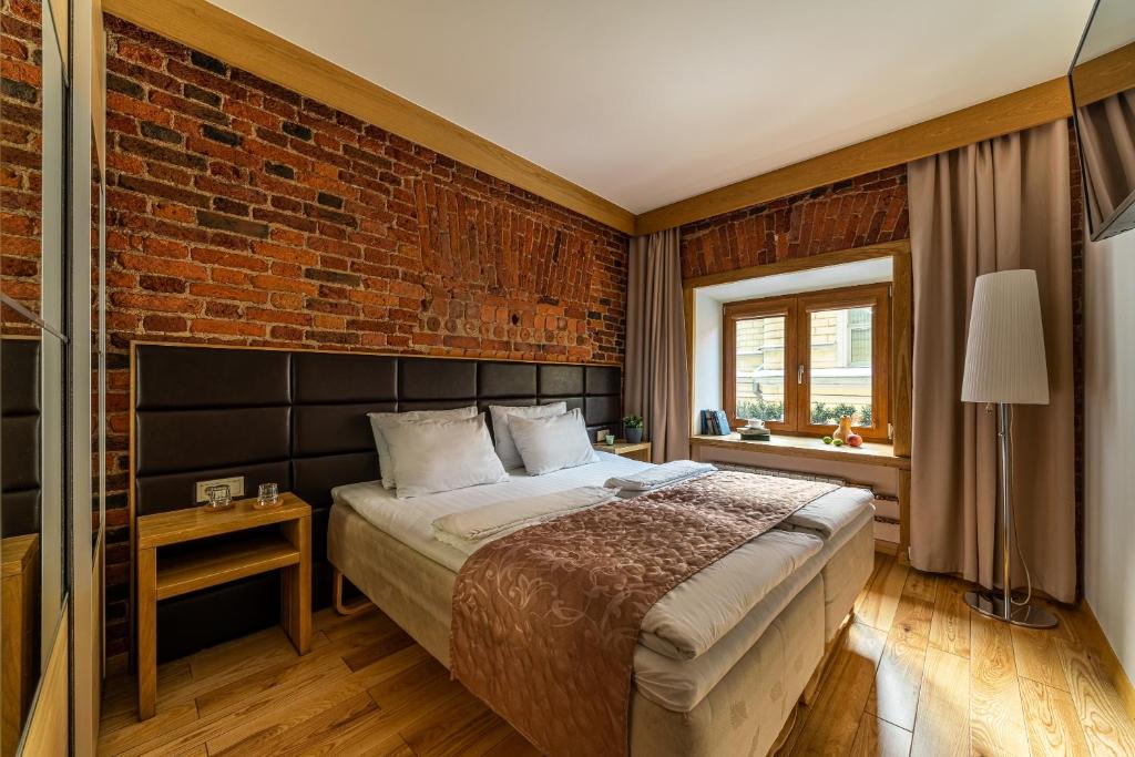 a bedroom with a bed and a brick wall at Zen Hermitage in Saint Petersburg