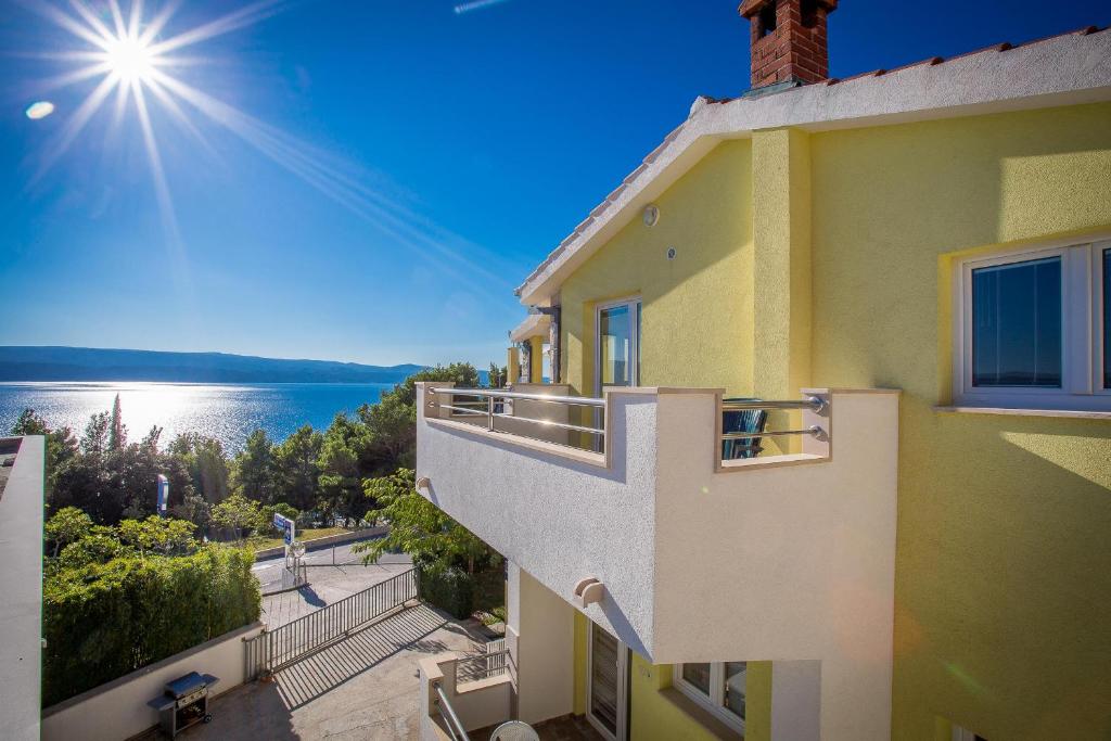 un edificio con balcone affacciato sull'acqua di Apartments Emil a Lokva Rogoznica