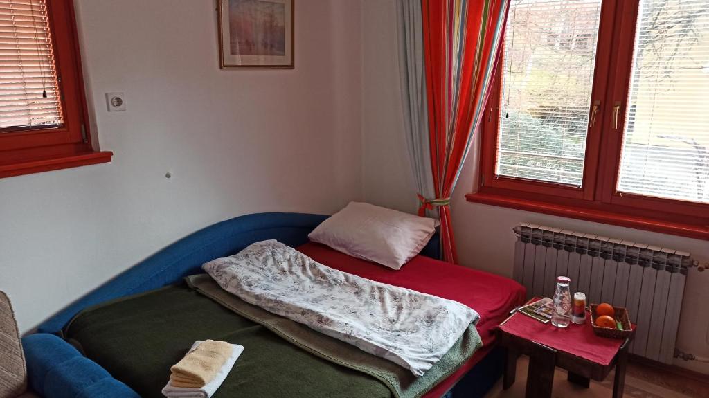 ein kleines Zimmer mit einem Bett mit einer Decke darauf in der Unterkunft Cozy room with a bathroom in Sarajevo