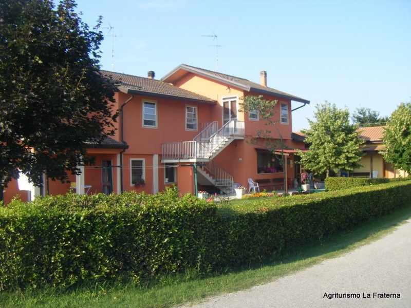a large orange house with a hedge in front of it at Agriturismo La Fraterna in Tolle