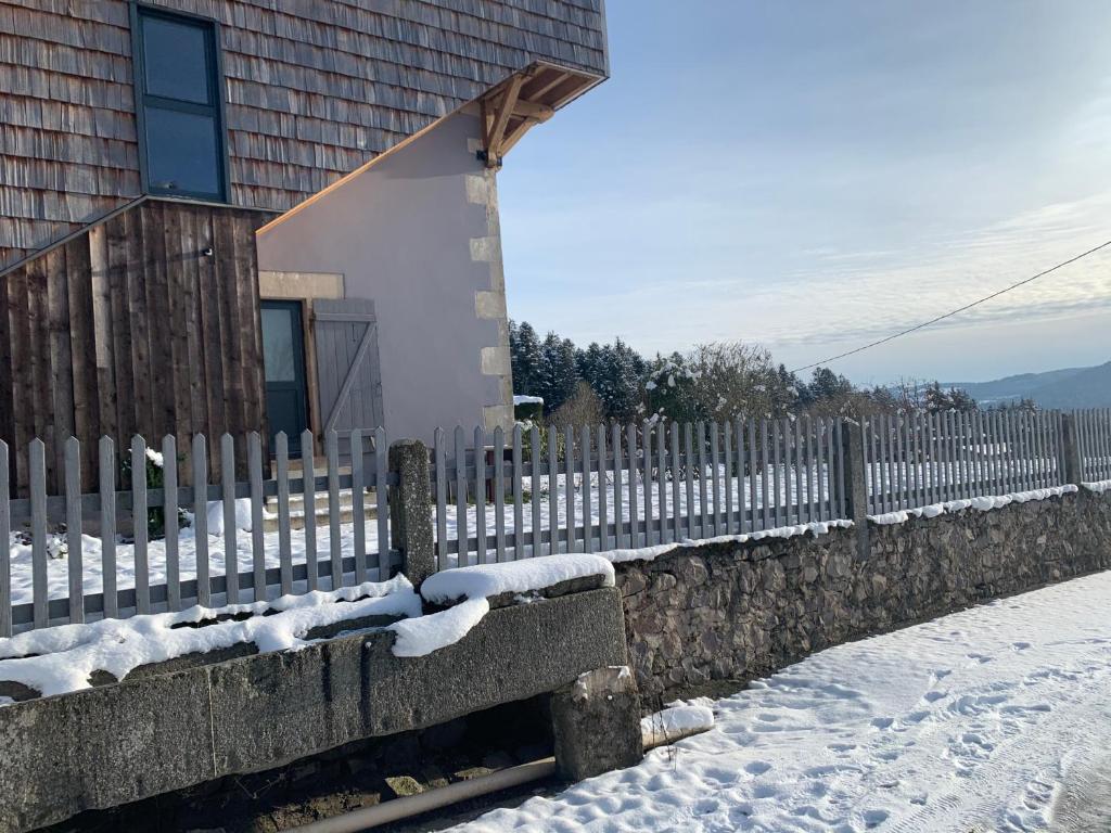 una cerca cubierta de nieve junto a una casa en GITE AVEC VUE MAGNIFIQUE en Saint-Étienne-lès-Remiremont