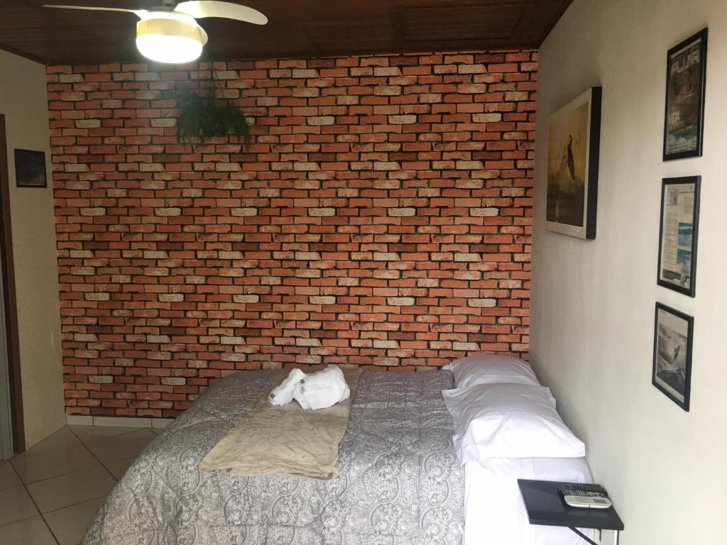 pared de ladrillo con cama en una habitación en Pousada Schlickmann, en Florianópolis