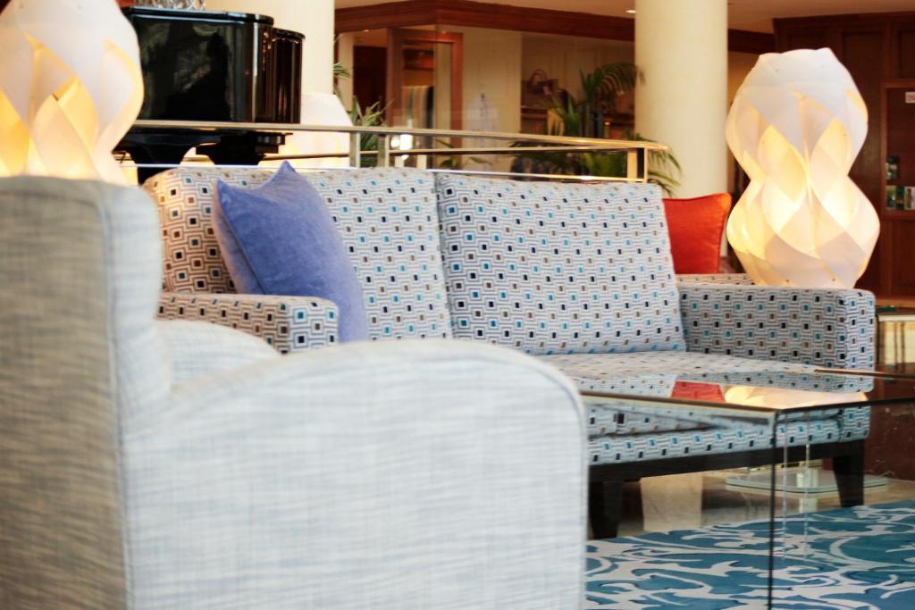 a blue and white couch with a table and chairs at Grupotel Parc Natural & Spa in Playa de Muro