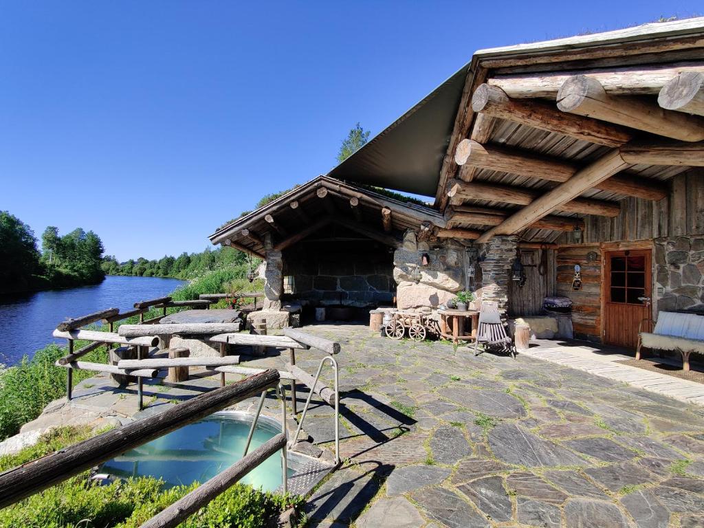 a log cabin with a pool in front of it at Lapuanjoen Rantakeidas in Voltti