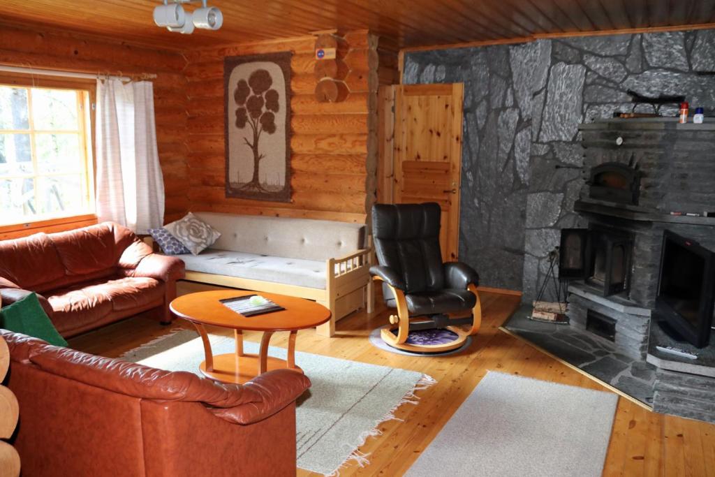 a living room with a couch and a fireplace at Aronsalmen Lomamökit in Nurmes