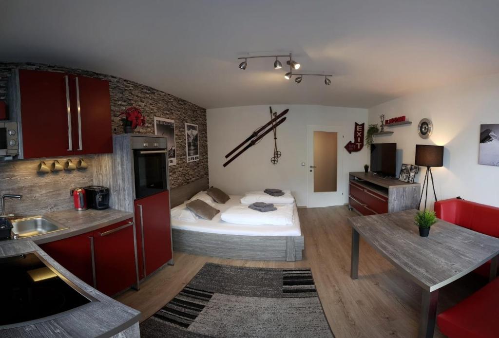 a kitchen with a bed in the middle of a room at Retro Apartment in Kaprun