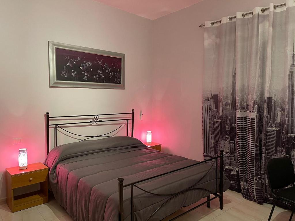 a bedroom with a bed with pink lights on it at Station's Room in Avellino