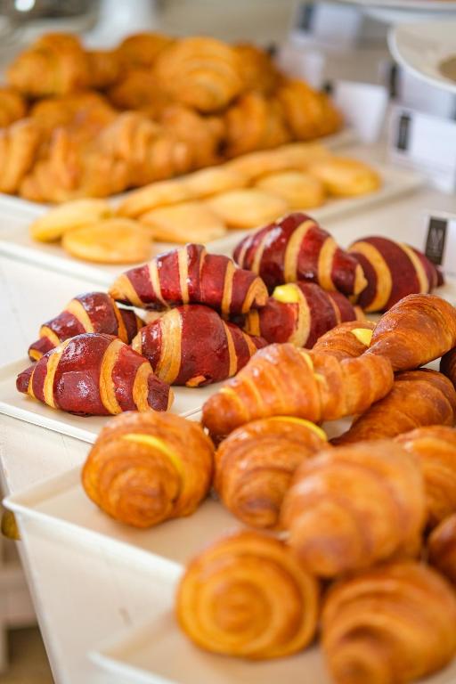 a bunch of different types of pastries on plates at Borgobianco Resort & Spa Polignano - MGallery Collection in Polignano a Mare