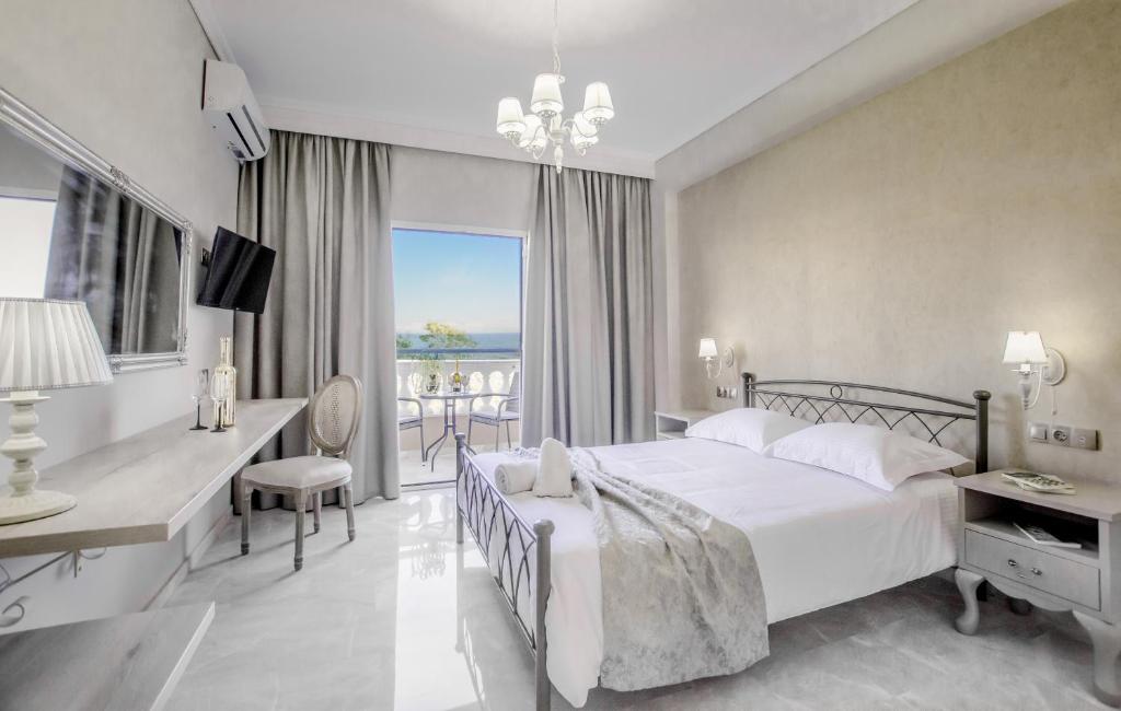 een slaapkamer met een bed, een bureau en een raam bij Erofili Hotel in Kavos