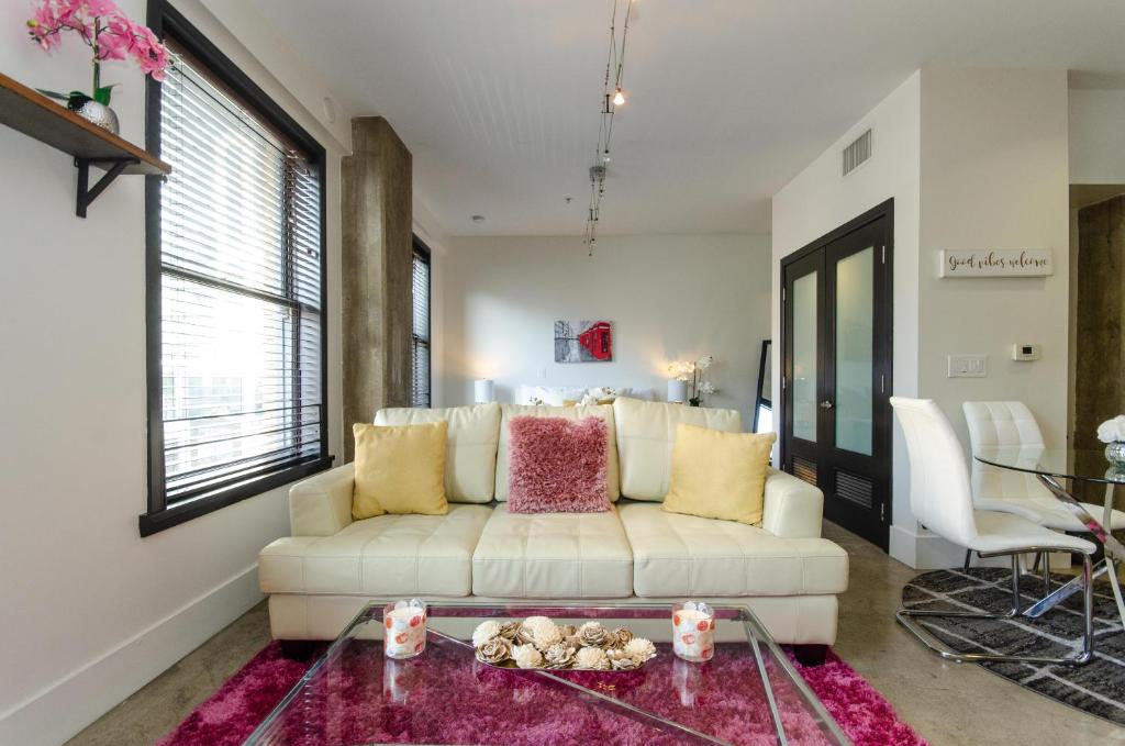uma sala de estar com um sofá branco e uma mesa em Modern Loft with Rooftop Lounge in DTLA em Los Angeles
