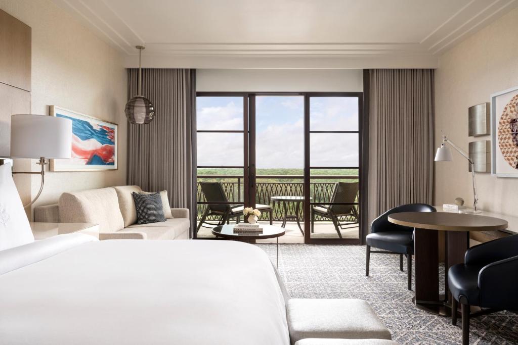 a hotel room with a bed and a living room at Four Seasons Resort Orlando at Walt Disney World Resort in Orlando