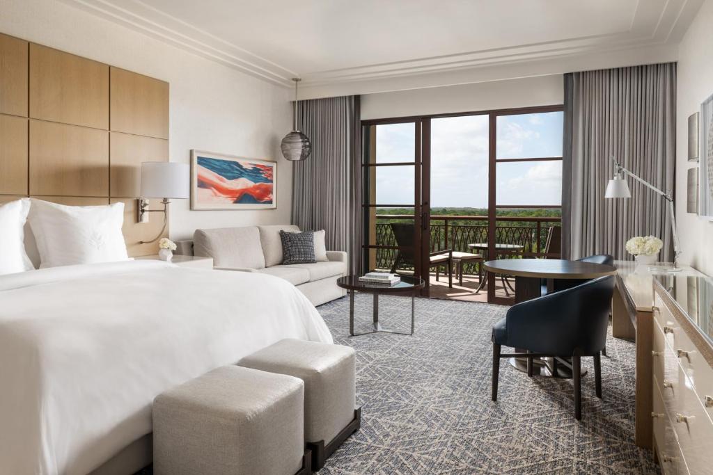 a bedroom with a large bed and a living room at Four Seasons Resort Orlando at Walt Disney World Resort in Orlando