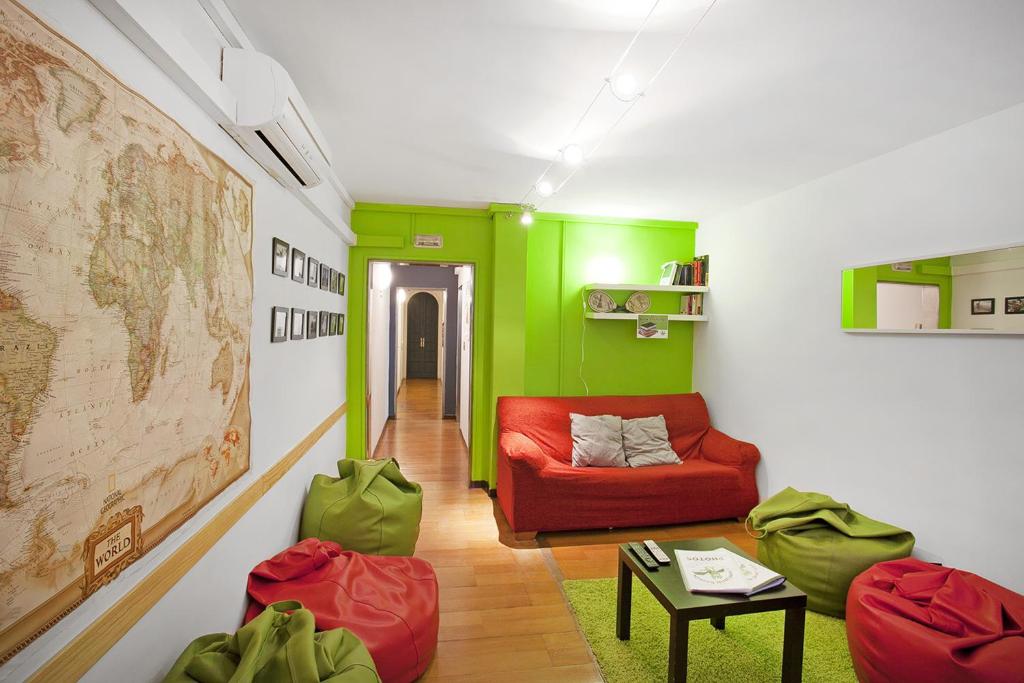 バルセロナにあるDiagonal House Hostelの赤いソファと緑の壁が備わるリビングルーム