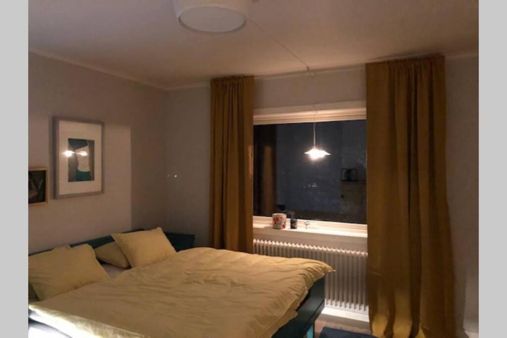 1 dormitorio con cama y ventana en Villa Kuriosa SKOGSFEEN, en Ytterhogdal