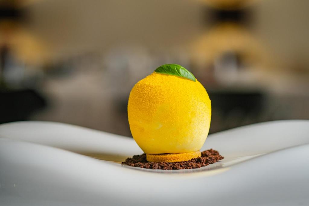a lemon sitting on top of a white plate at Borgobianco Resort & Spa Polignano - MGallery Collection in Polignano a Mare