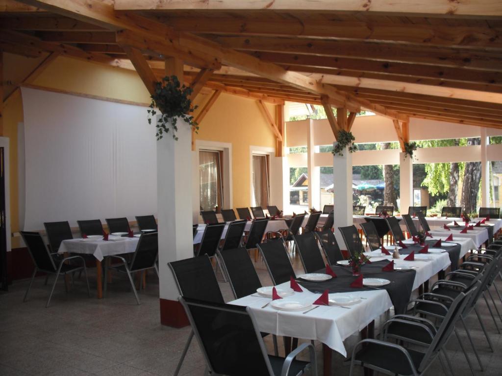 una fila de mesas y sillas en una habitación en Centrum Étterem és Panzió en Őriszentpéter