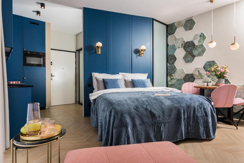 a bedroom with blue walls and a bed and a table at Rakowicka Apartments Nearto Old Town in Kraków