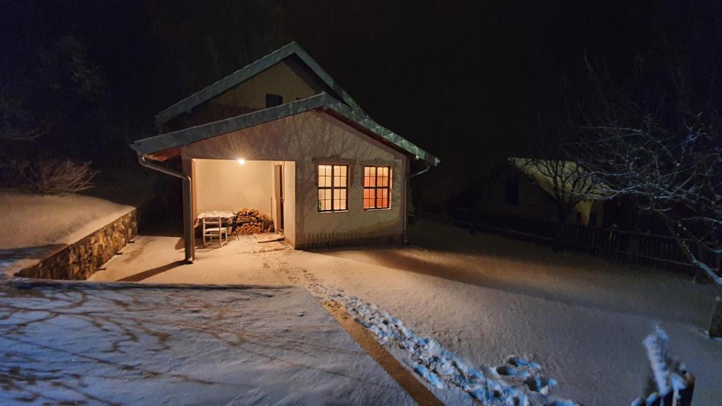 a small house in the snow at night at Kuća za odmor Virtus Goč in Vrnjačka Banja
