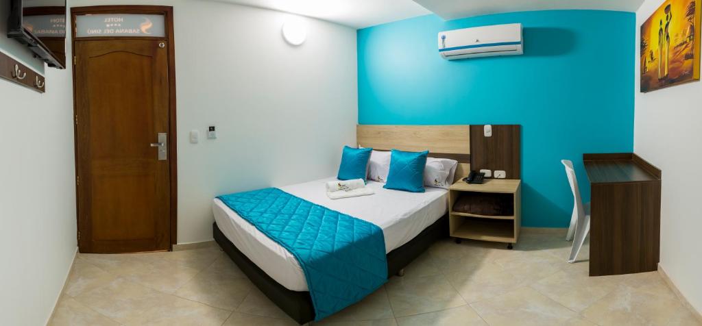 um quarto com uma cama com uma parede azul em Hotel Sabana del Sinu By GEH Suites em Montería